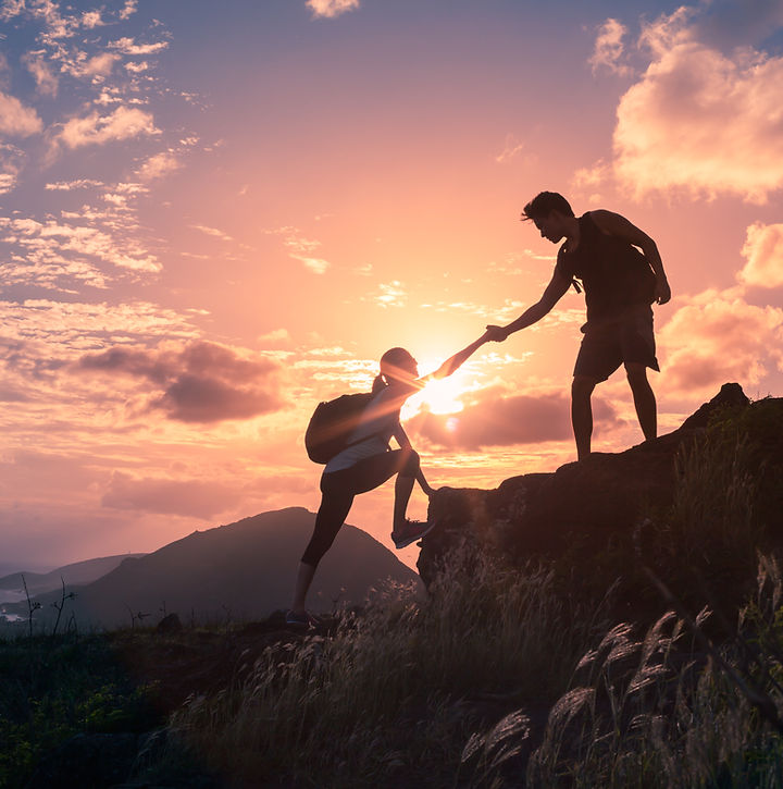People helping each other hike up a moun